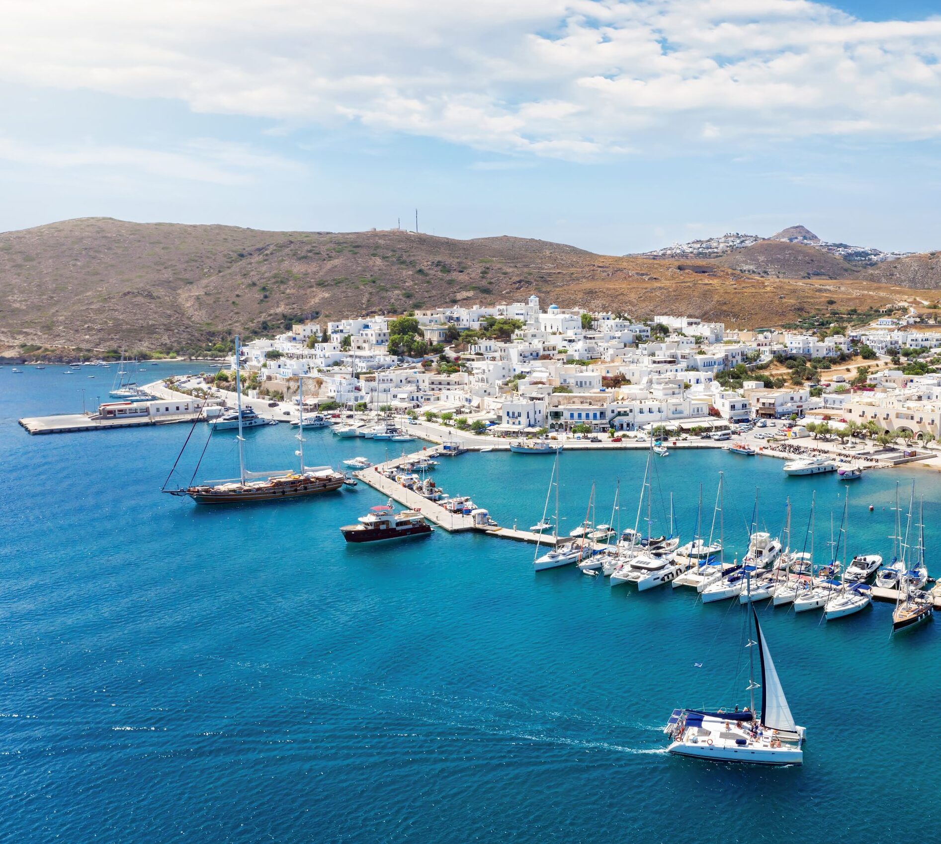 Aerial view of Adamas port and the town of Milos with moored boats